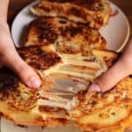 pulling apart a pulled pork grilled cheese by hand