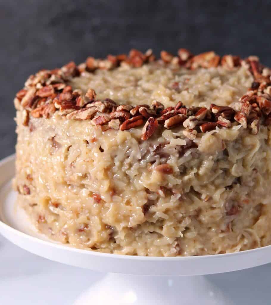 German chocolate cake with pecans on a white cake stand