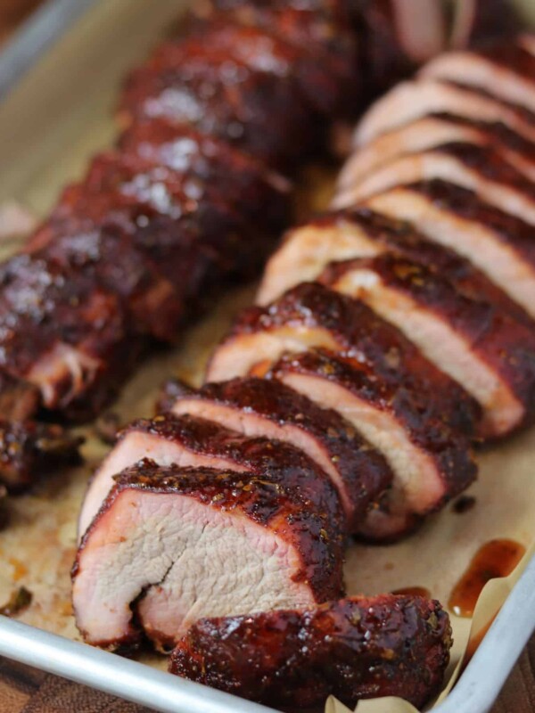 sliced pork tenderloin on a sheet pan lined with parchment paper
