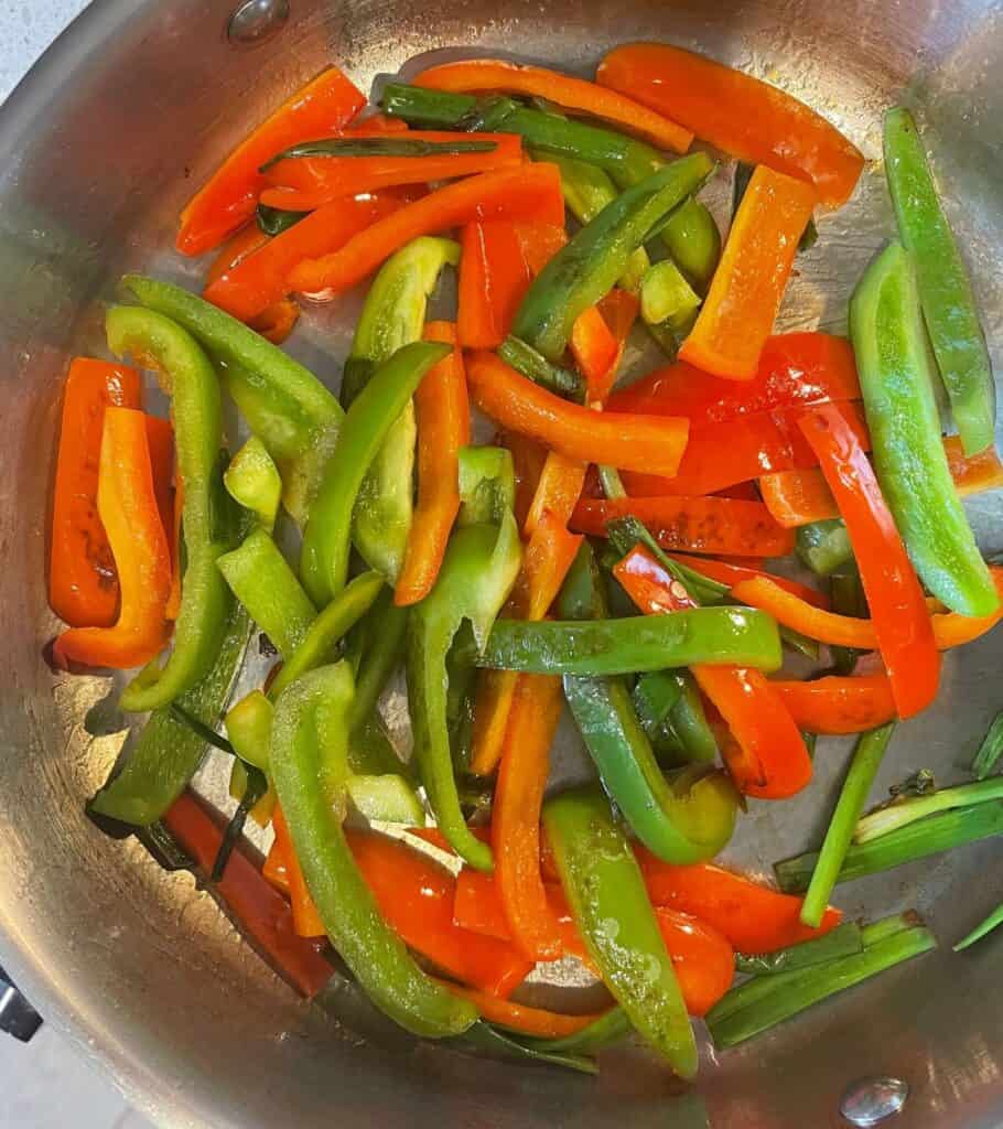 bell pepper strips and scallion greens in a skillet