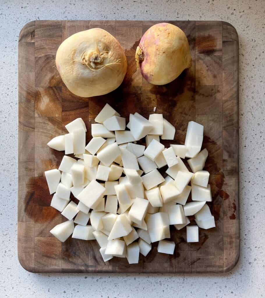 two unpeeled turnips next to peeled and chopped turnip