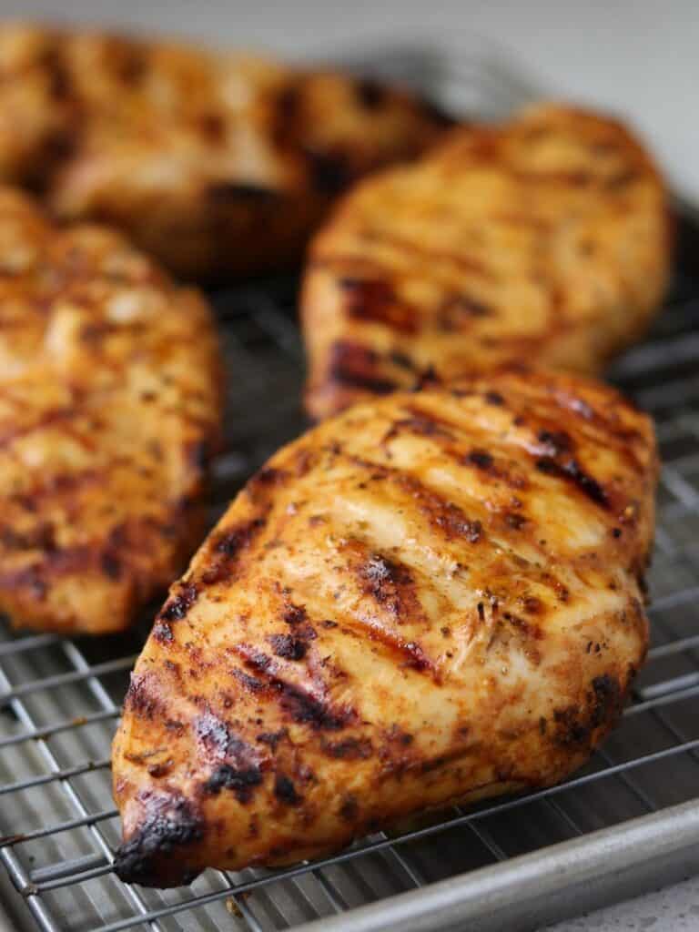 4 grilled chicken breasts on a wire rack