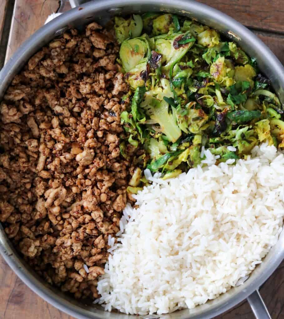 honey balsamic ground chicken in a sauté pan with shaved brussels sprouts and cooked rice