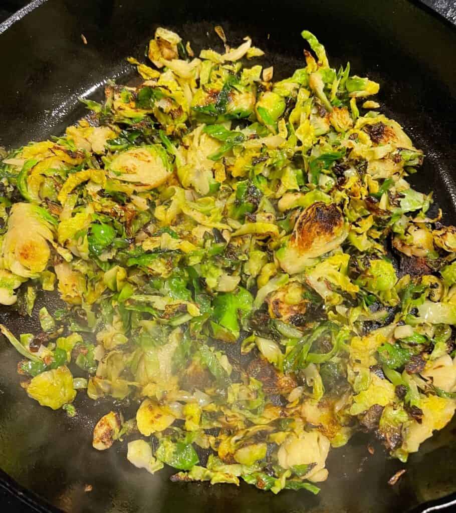 sautéed shaved brussels sprouts in a cast iron skillet