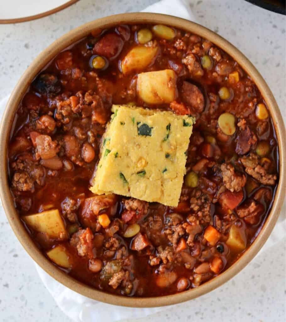 bowl of stew with a piece of cornbread 