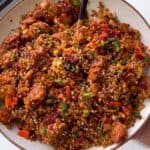 bbq chicken fried cauliflower rice garnished with chives, sesame seeds, and chili crisp