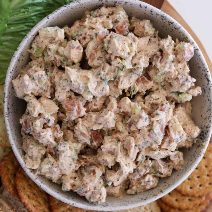 smoked chicken salad in a bowl served with crackers, lettuce, and bread