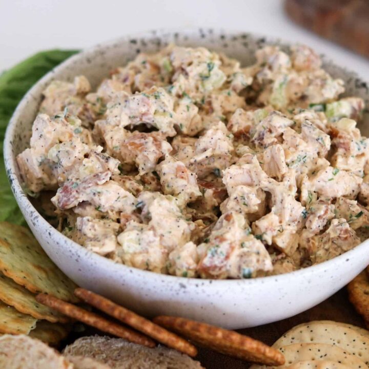 smoked chicken salad in a bowl with crackers, bread, lettuce, and lemon