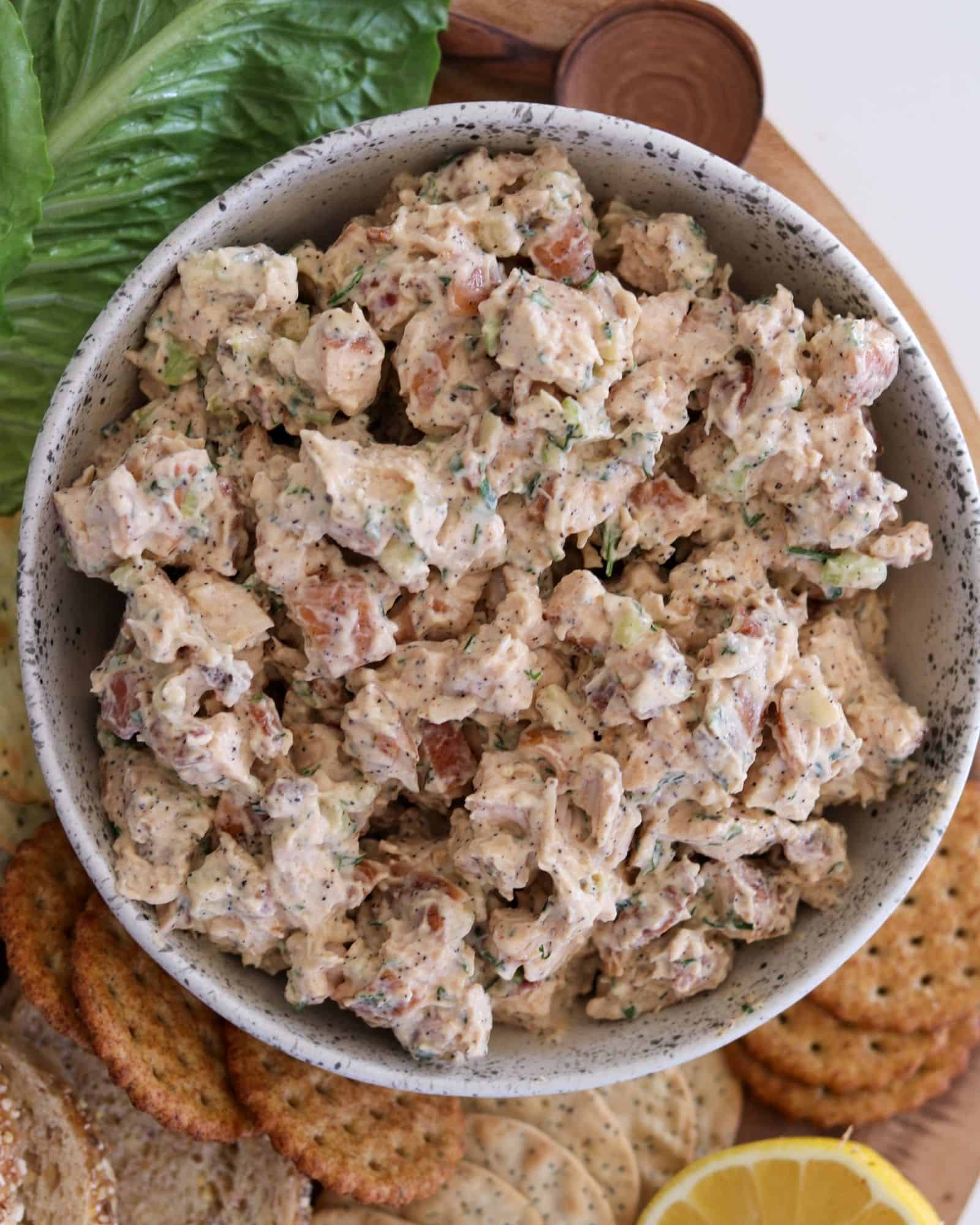 smoked chicken salad in a bowl served with crackers, lettuce, and bread