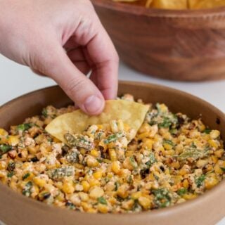 scooping esquites with a tortilla chip