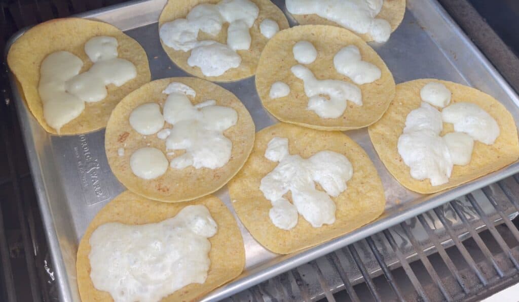 tortillas with cheese on a sheet pan in a Traeger grill