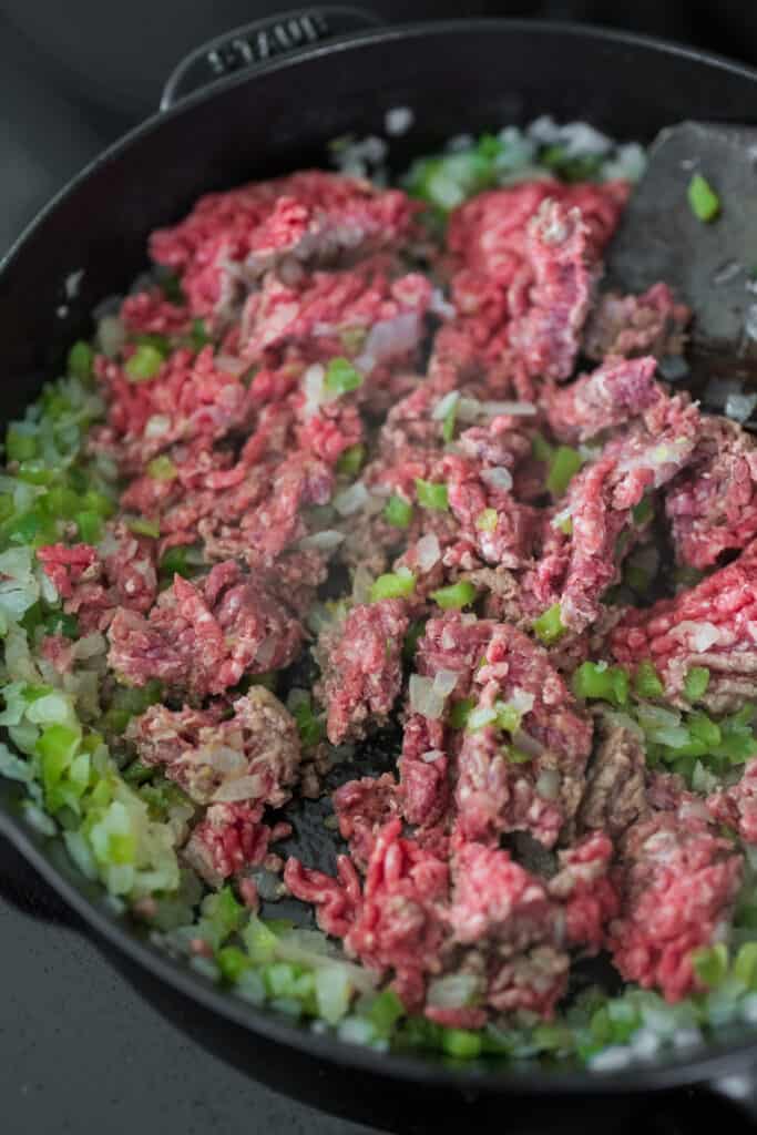 cooking ground beef with onion and pepper in a cast iron skillet