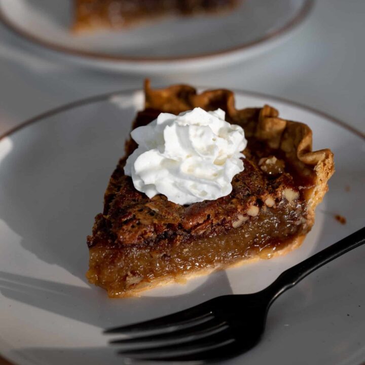 slice of pecan pie with whipped cream on top