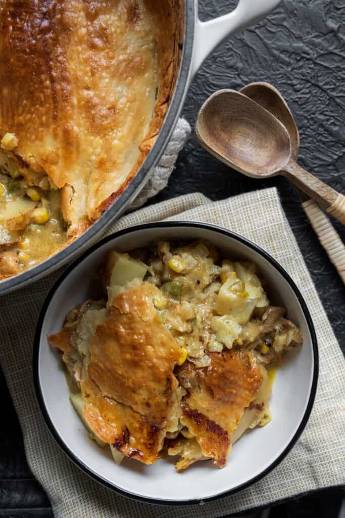 one serving of Mexican chicken pot pie in a bowl beside a Dutch oven pot pie