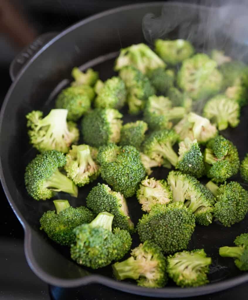 broccoli florets in a skillet with olive oil