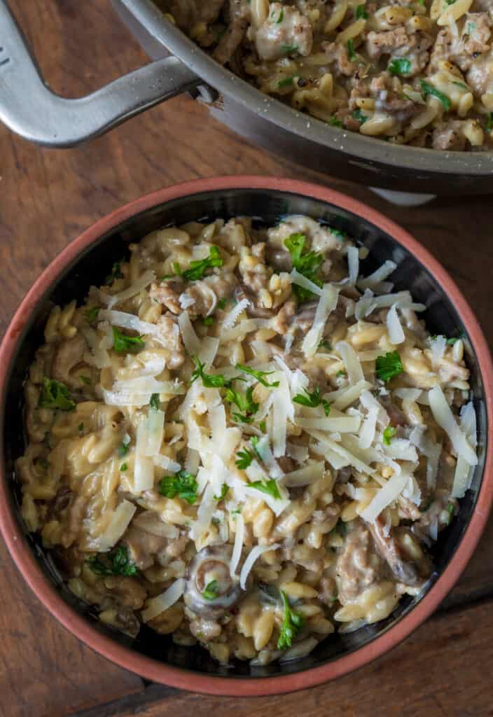 ground turkey mushroom orzo in a bowl garnished with grated parmigiano reggiano 