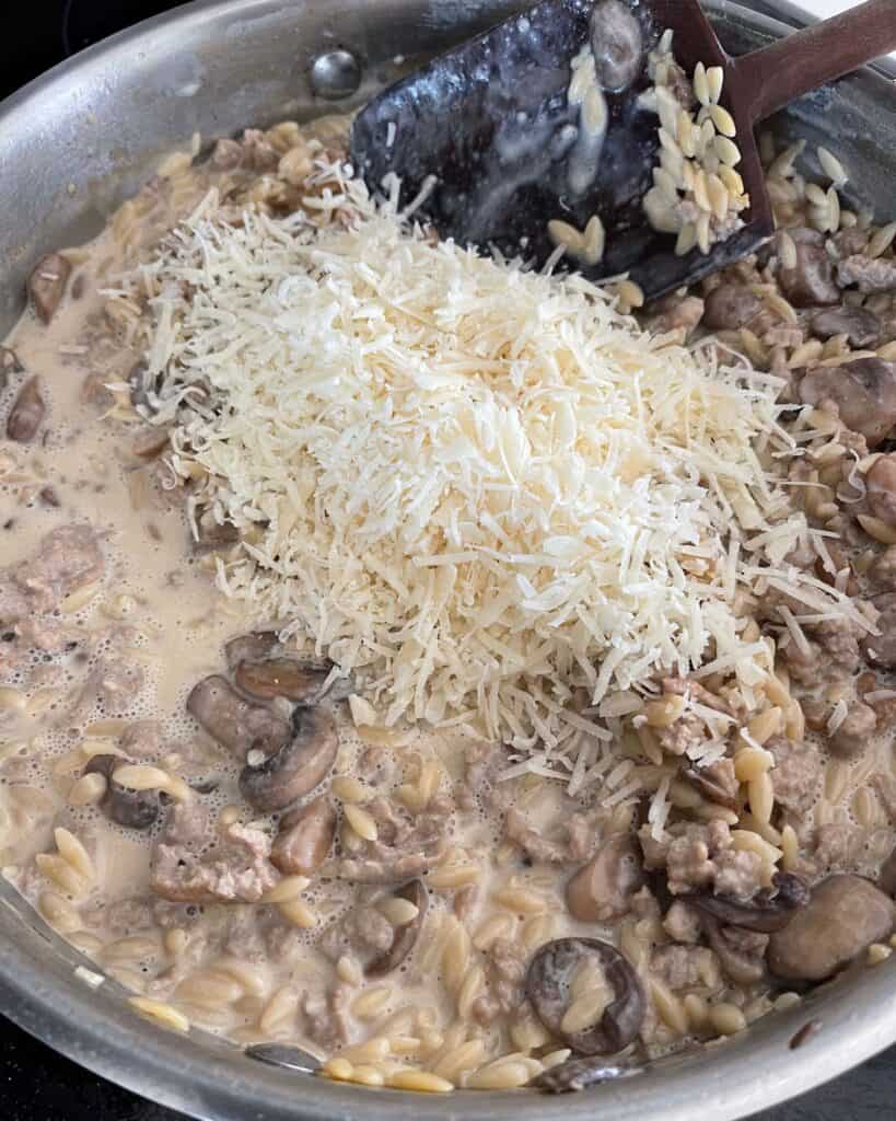 grated parmigiano reggiano on top of cooked ground turkey and mushroom orzo 