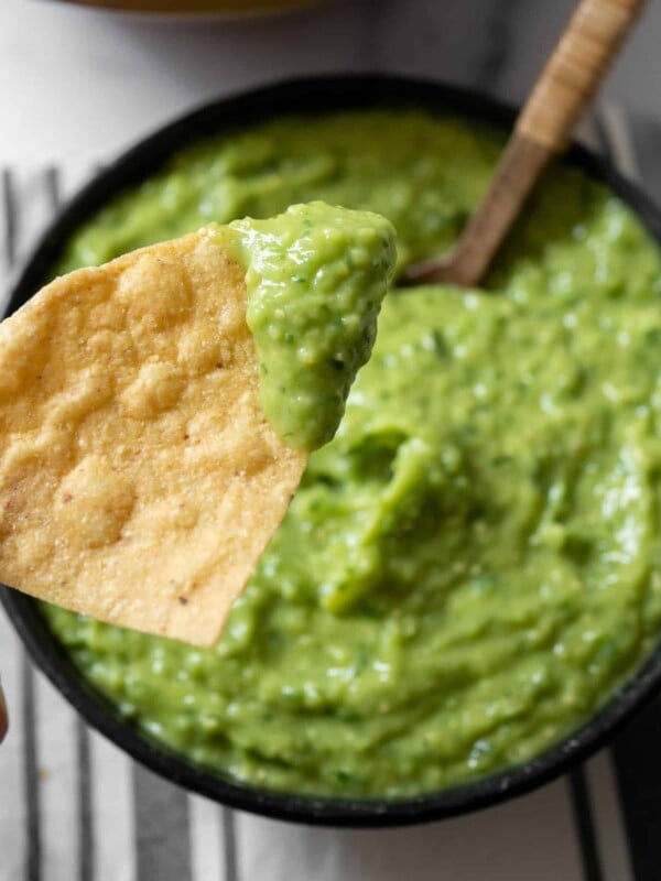 dipping a tortilla chip in a bowl of smoked guacamole salsa