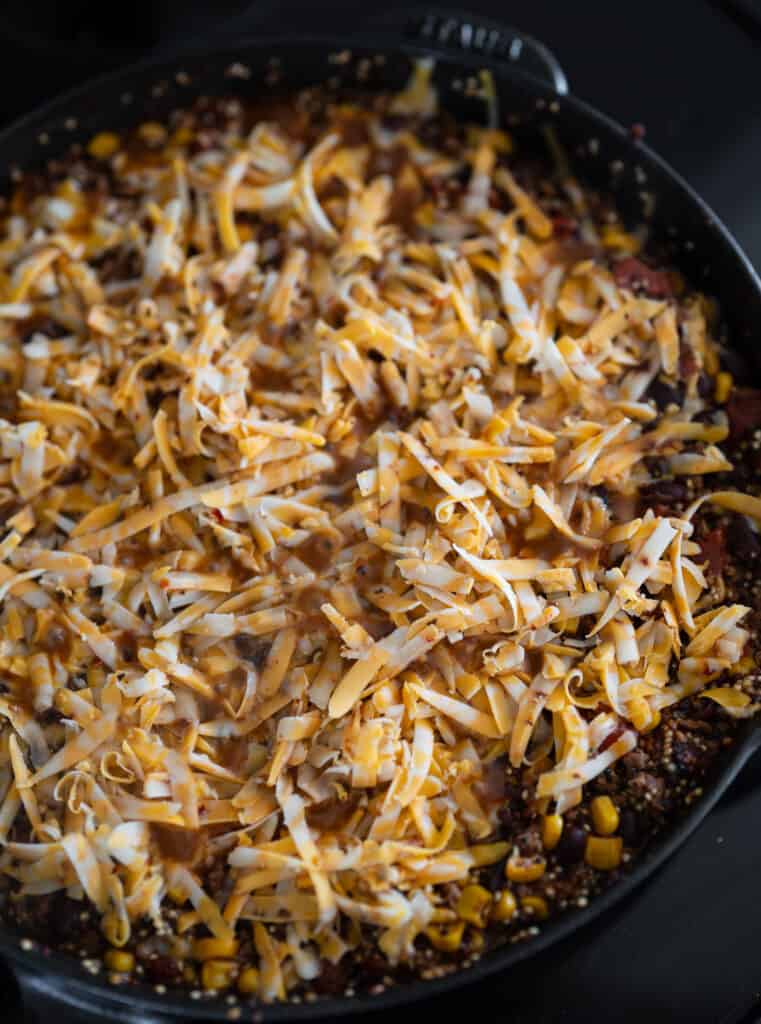 shredded cheese on top of the ground beef and quinoa skillet