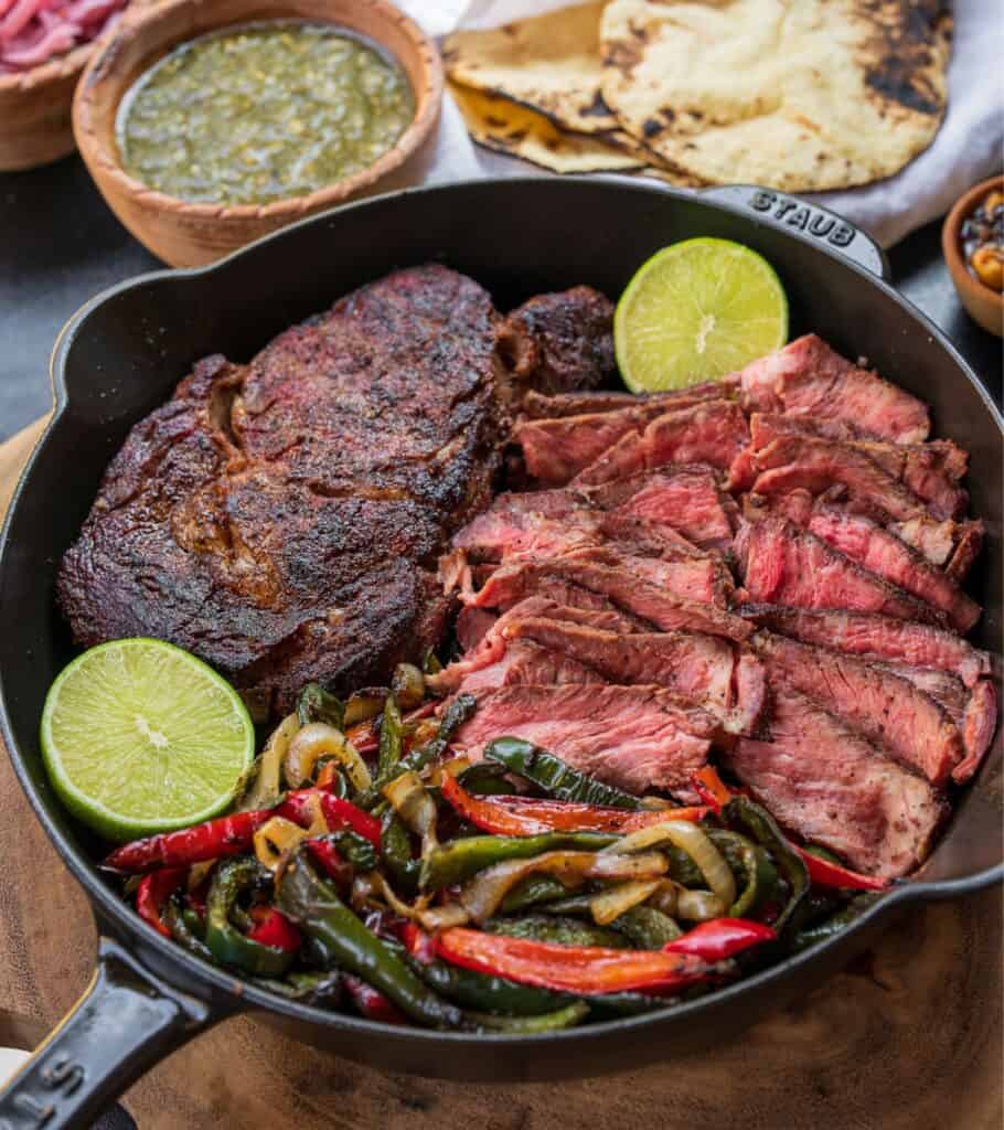 ingredients for Traeger ribeye steak tacos in a cast iron skillet on the Traeger ironwood shelf