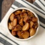 Traeger smoked garlic cloves in a white bowl