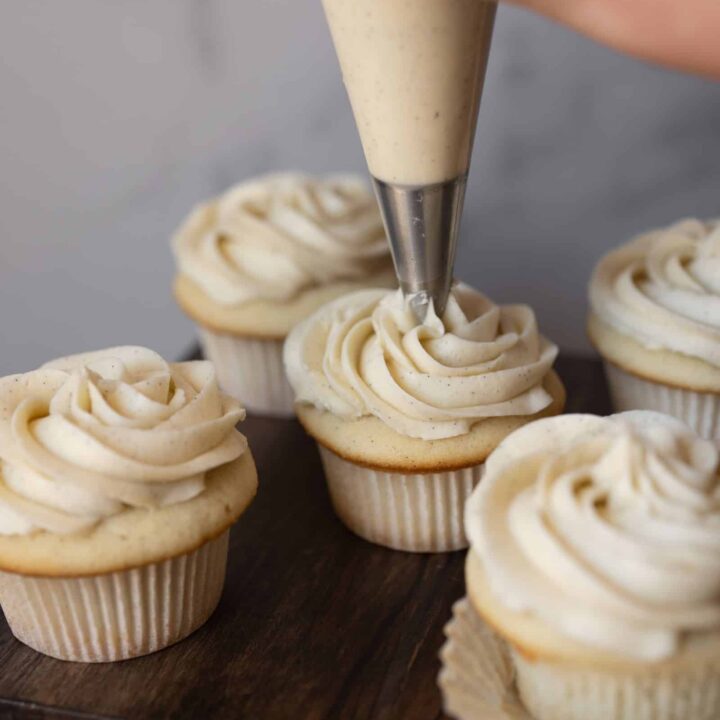 Vanilla bean buttercream being piped onto a cupcake.