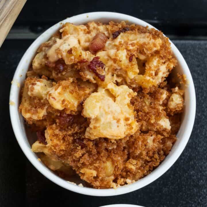 scoop of pellet smoked mac and cheese in a white bowl on the front rack of a Traeger grill