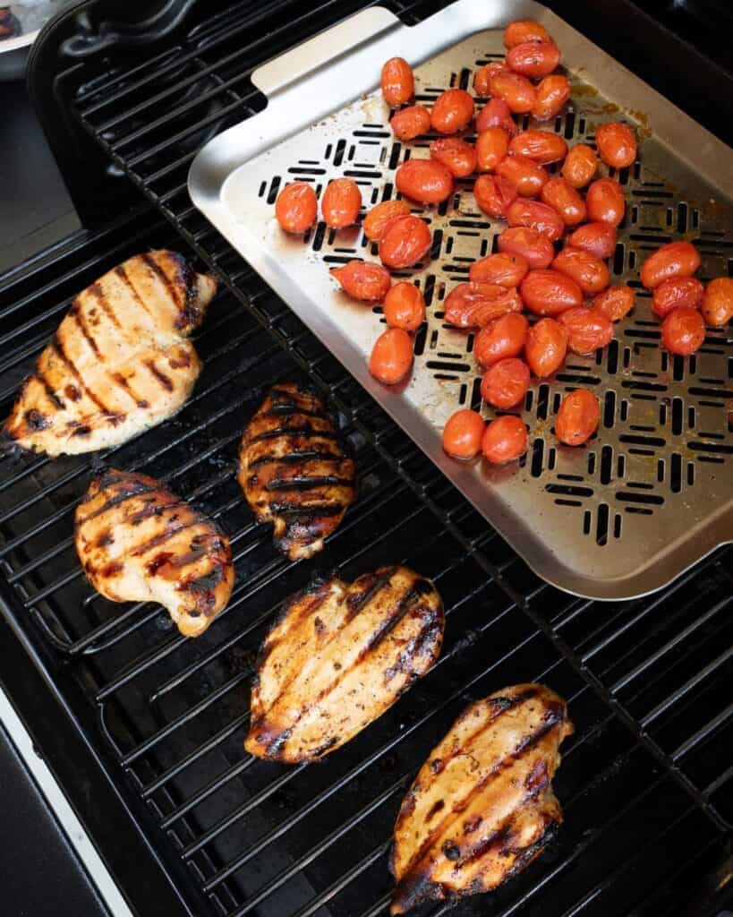 grilled chicken breast on a Traeger grill with tomatoes on a grill pan