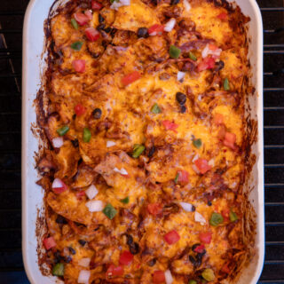 smoked enchilada casserole in a baking dish on a Traeger grill